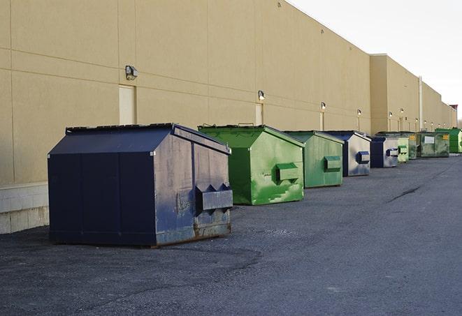 a construction worker moves construction materials near a dumpster in Gilbert AZ